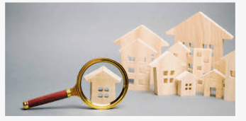 Small wooden houses with a magnifying glass over one
